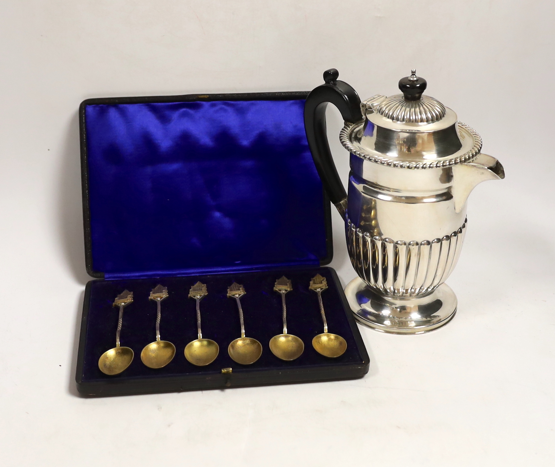 A late Victorian demi fluted silver hot water pot, Charles Favell & Co, Sheffield, 1898, gross weight 11.8oz and a cased set of six silver gilt teaspoons with throne terminals.
